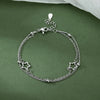 Sterling silver double heart charm bracelet with a chain and star charms displayed on a green background