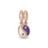 Rose gold charm pendant featuring a yin and yang design with purple and white stones.