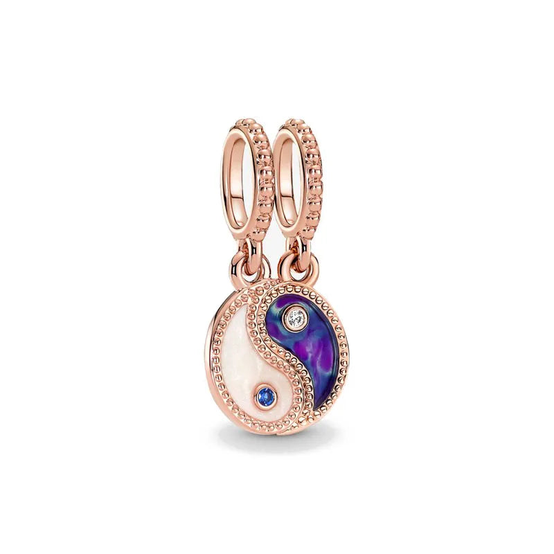 Rose gold charm pendant featuring a yin and yang design with purple and white stones.