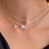 A delicate mother of pearl initial necklace featuring crystal accents, spelling out YW.