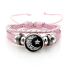 Pink braided bracelets featuring silver beads and a black disc with a crescent moon and star design