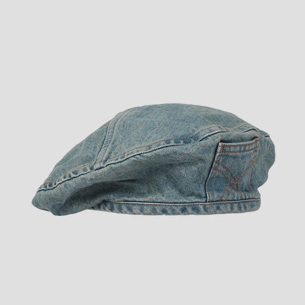 A close-up view of a retro washed cotton denim beret hat.