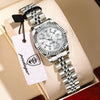 A silver watch with a black strap and a tag is displayed on a light-colored box.