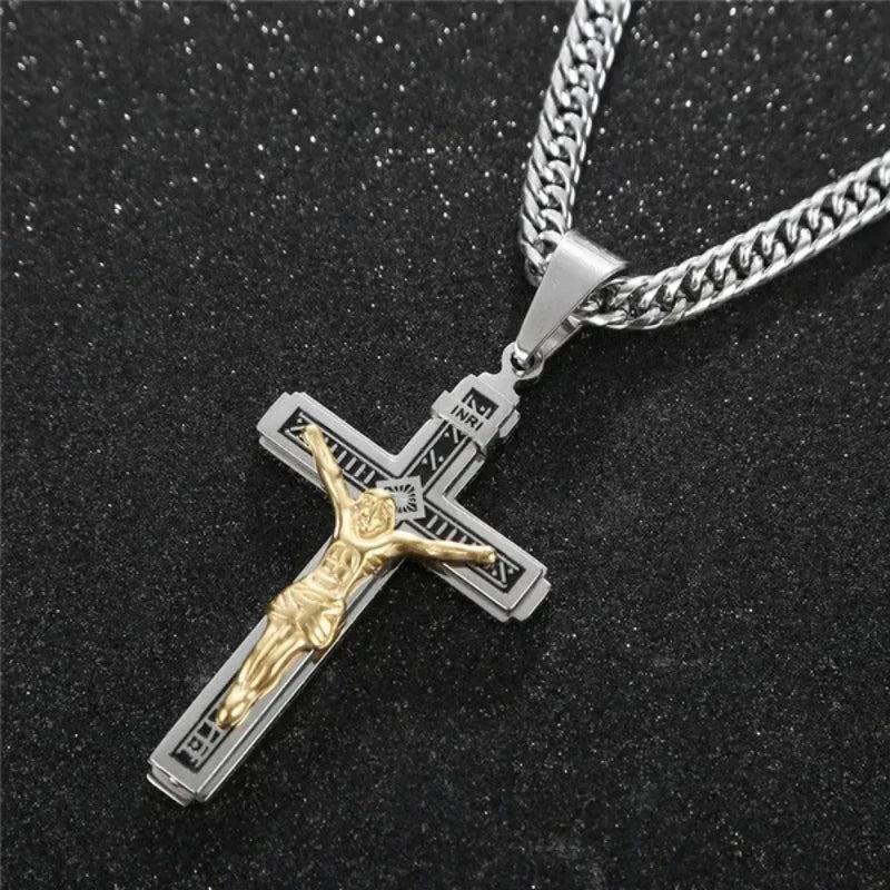 Collar de cruz de Jesús chapado en oro con cadena de plata sobre fondo negro.