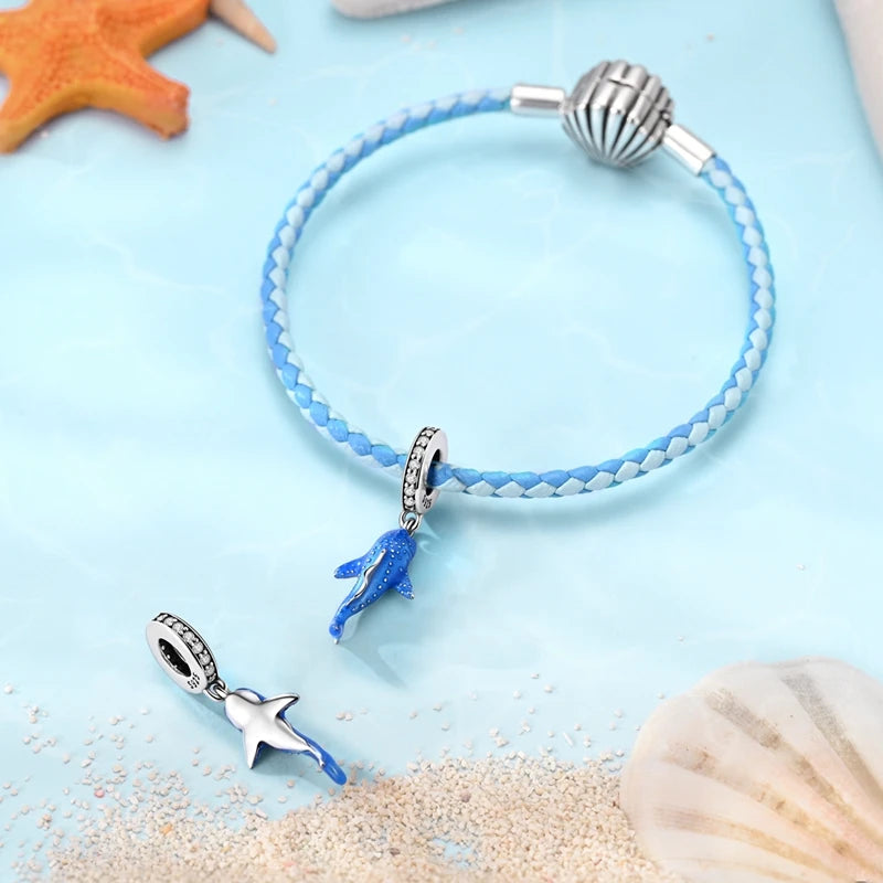 Sterling silver devil's eye charm bracelet with a blue bead and silver clasp on a light blue background