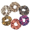 Un set de seis gomas para el pelo con estampado floral de satén en varios patrones de leopardo y floral.