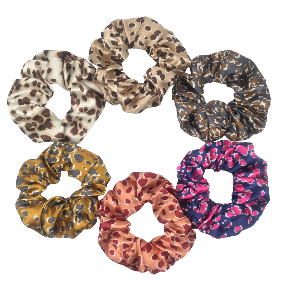 Un set de seis gomas para el pelo con estampado floral de satén en varios patrones de leopardo y floral.