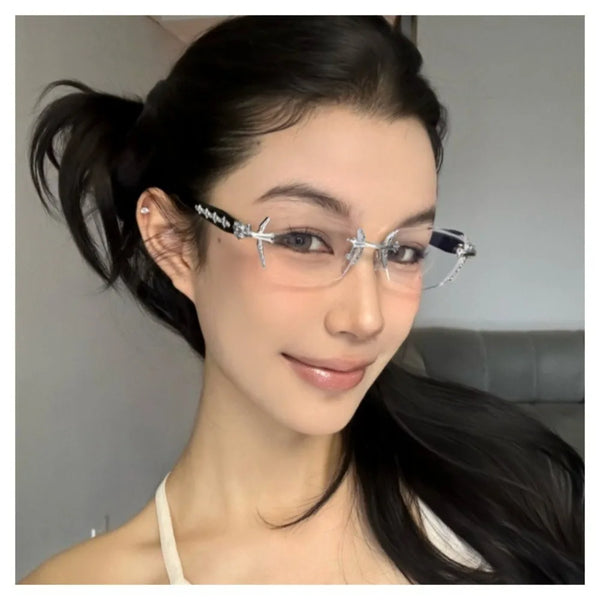 A close-up portrait of a woman wearing vintage Y2K frameless glasses with silver detailing.