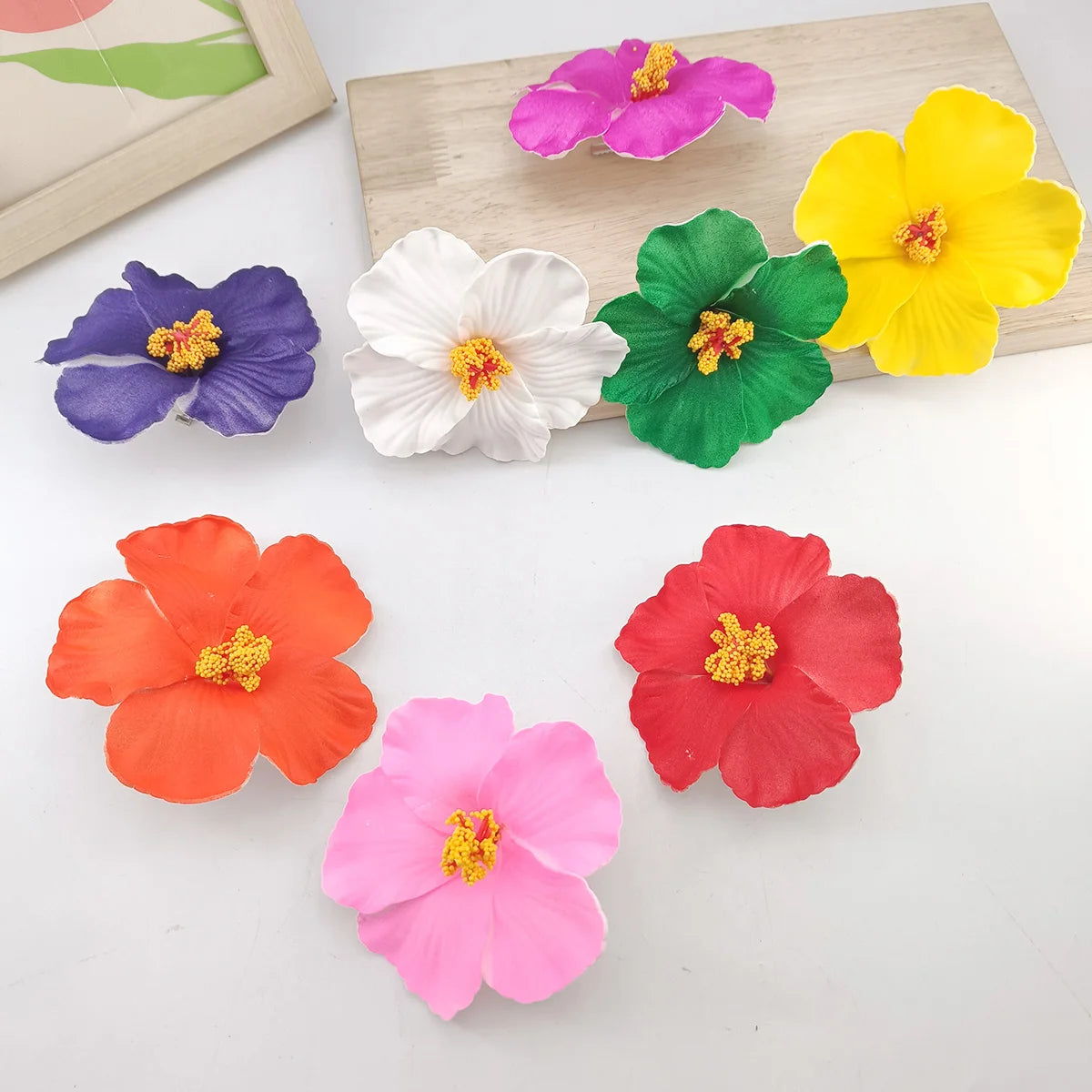 A set of colorful, delicate floral shapes in pink, orange, yellow, purple, and green on a wooden surface.