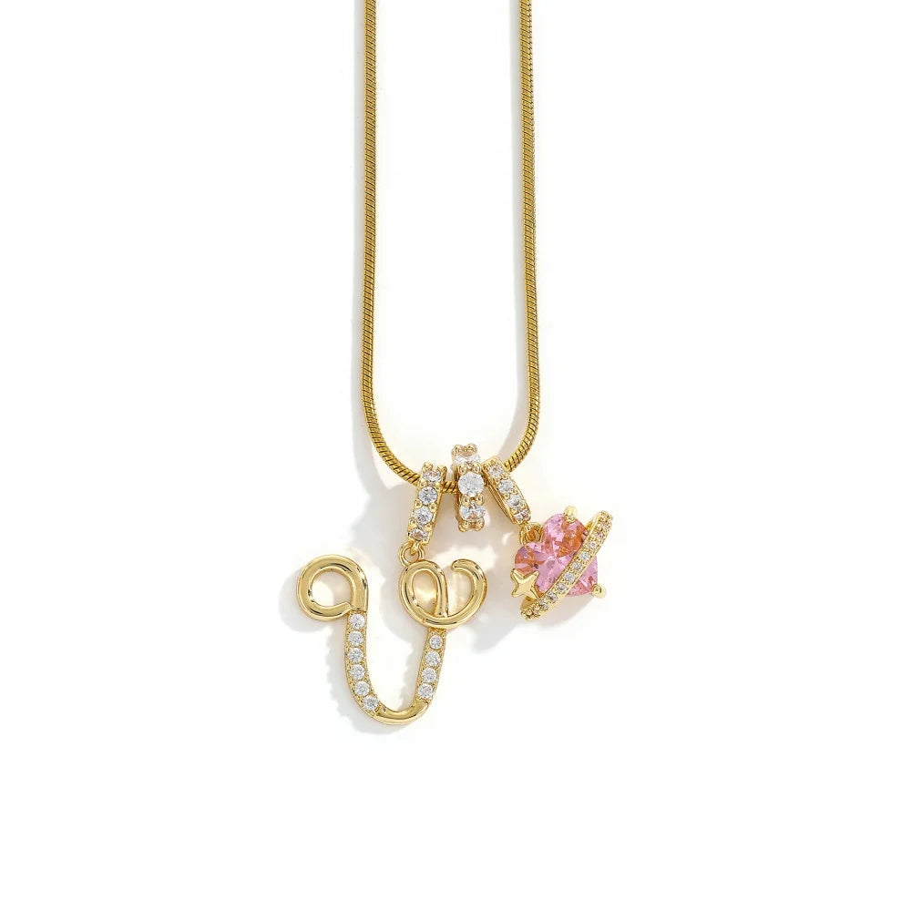 A gold-toned alphabet flower pendant necklace with a delicate chain and pink gemstone accents.