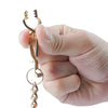 A hand holds a durable metal glove clip holder with a decorative charm.
