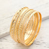 A stack of elegant gold hexagon star twist bangles displayed on a white surface.