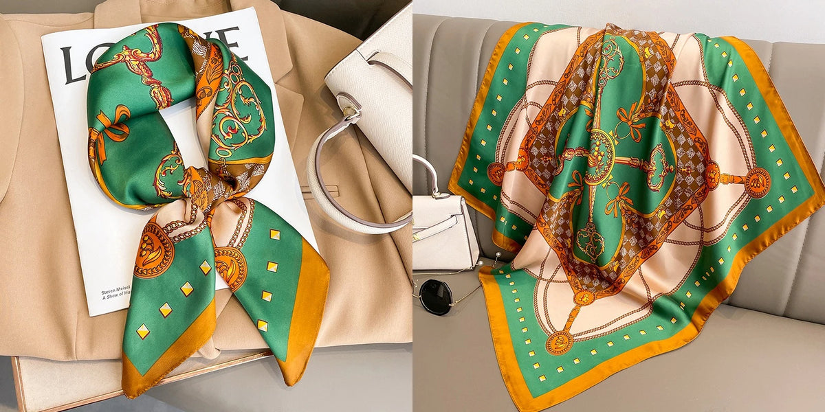 A silk scarf with a floral print featuring green, orange, and gold tones draped on a beige fabric.