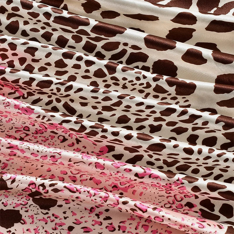 Close-up of a flowing fabric featuring a brown and white leopard print in satin material.