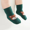 A pair of dark green knitted socks featuring a cute cartoon brown bear face.