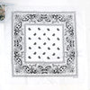 A white fabric featuring a black paisley bandanna pattern with intricate borders and a central square design.