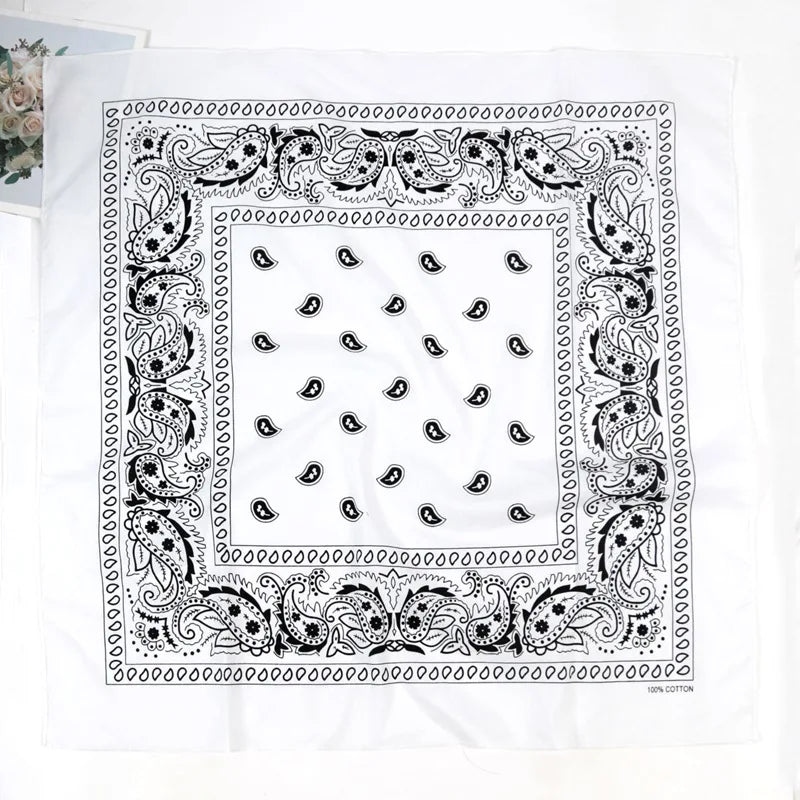 A white fabric featuring a black paisley bandanna pattern with intricate borders and a central square design.