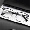 A pair of clear anti-blue light eyeglasses resting on a white surface.