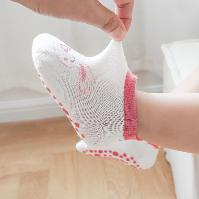 Nahaufnahme eines weißen Baumwollsock mit rosa Cartoon-Hörnchenmuster und rosa Akzenten am Knöchel.