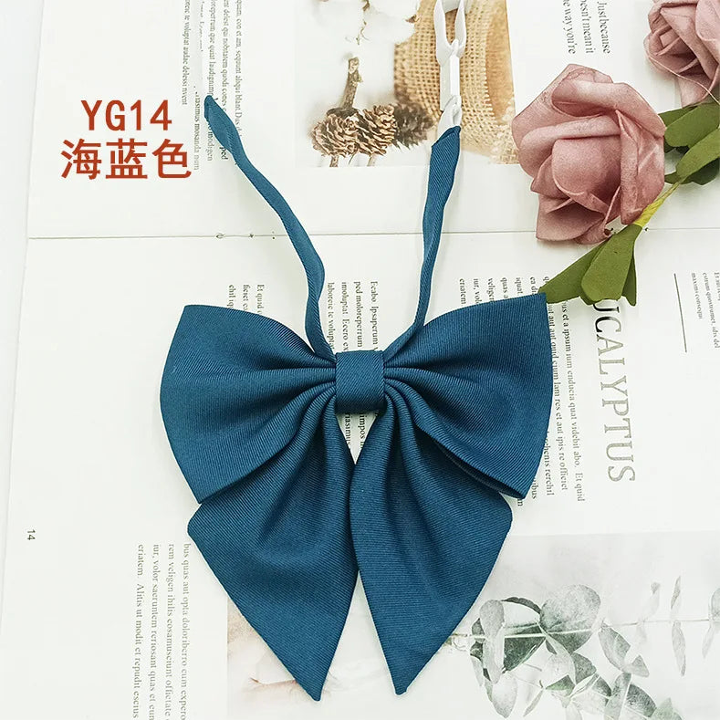 A dark blue solid cotton bow tie displayed on a white background.