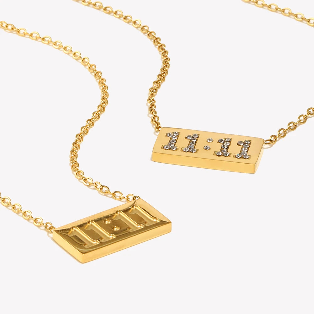 A gold plated rectangle pendant necklace with a chain and the time 11:11 engraved on the pendant.