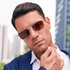 A man wearing retro vintage metal frame sunglasses and a blue suit jacket.