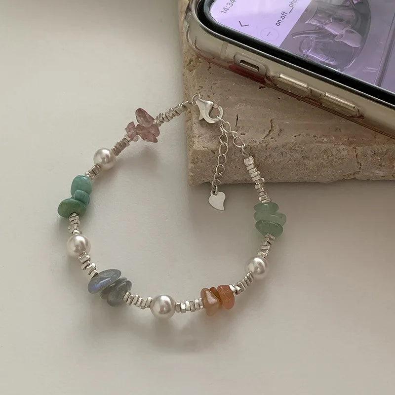 Sterling silver double heart charm bracelet featuring various colored stones and pearl accents