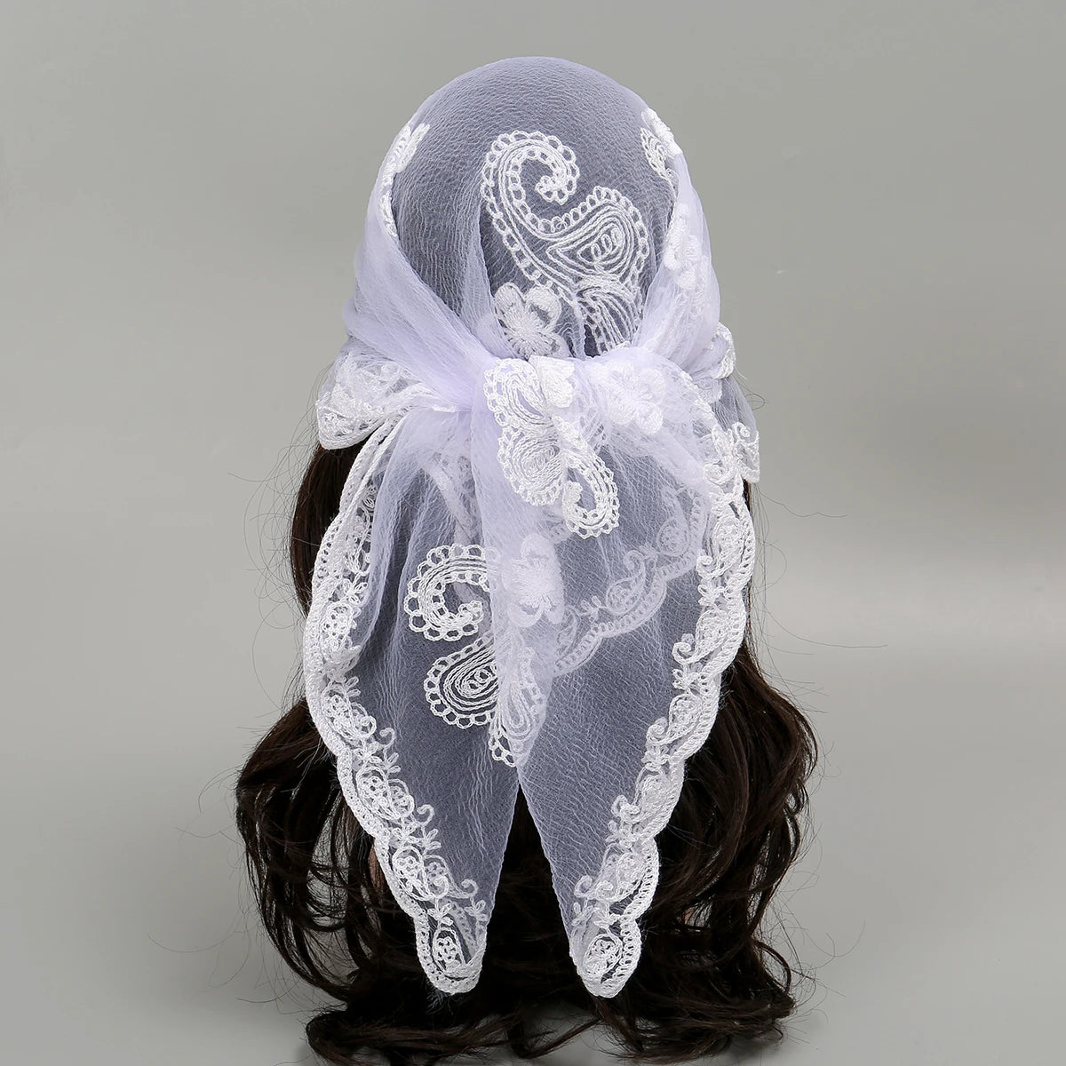 White floral embroidered lace bandana headscarf tied around dark hair