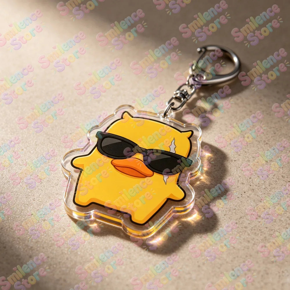 A clear acrylic keychain featuring a yellow, stylized character wearing black sunglasses.