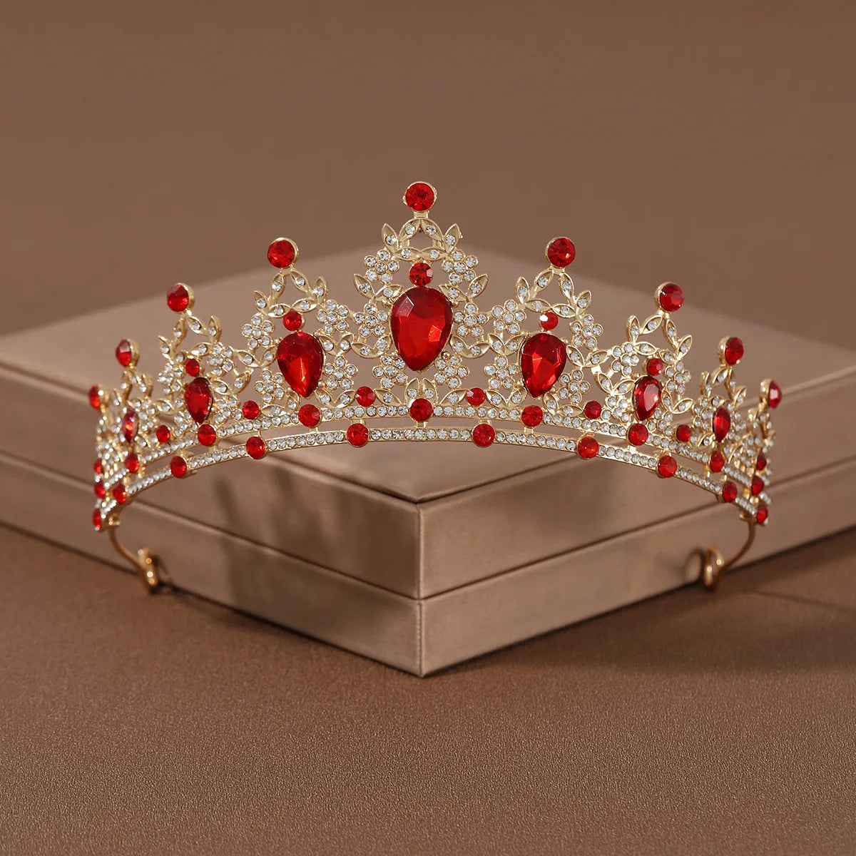 A sparkling crystal baroque bridal tiara featuring red gemstones and intricate silver-toned metalwork.