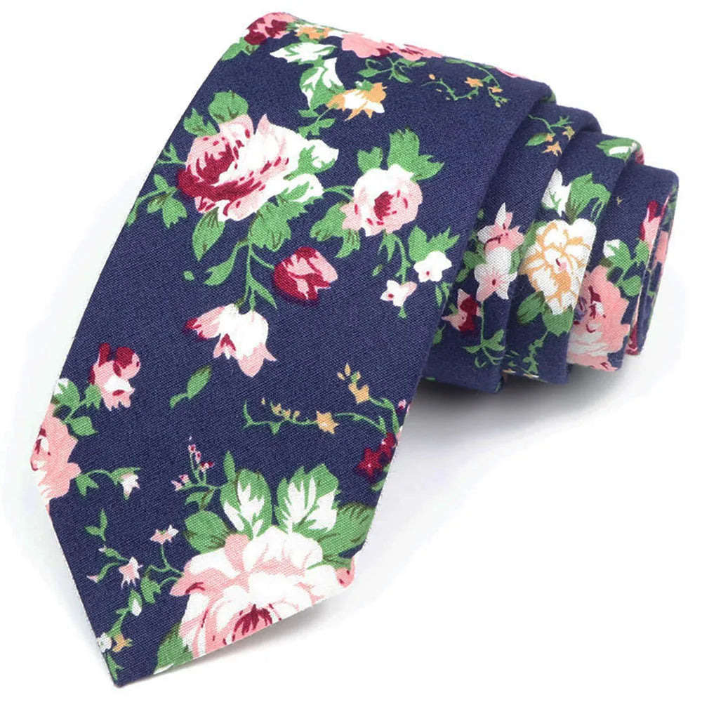 Une pile de nœuds papillon en coton à motifs floraux élégants, bleu marine avec des roses roses et crème.