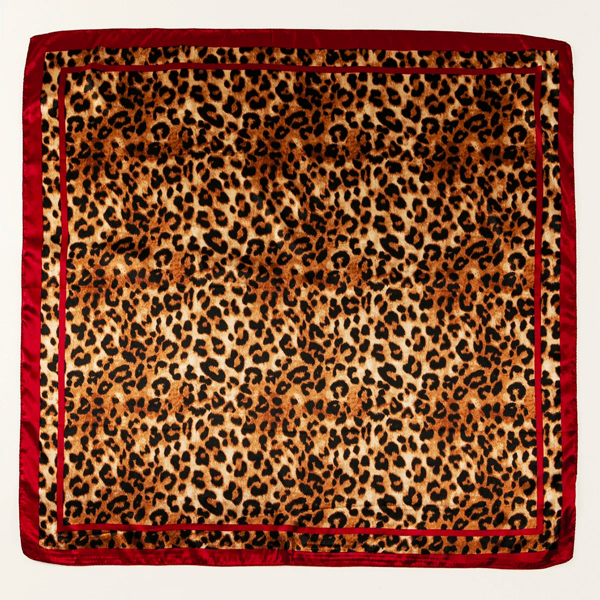 A square satin scarf featuring a leopard print design in shades of brown and black.