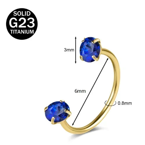 Gold-toned titanium nose ring featuring a blue cubic zirconia crystal.