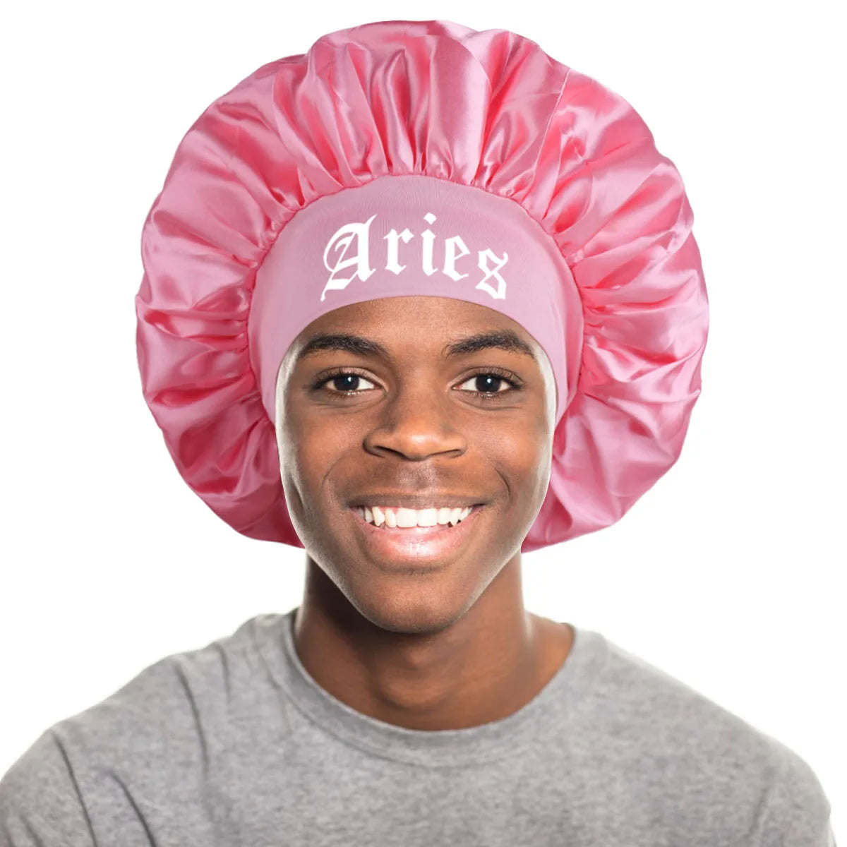 A young man wearing a pink satin sleep bonnet with an Aries wrap band.