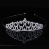 A sparkling crystal hair crown for women displayed on a black reflective surface.