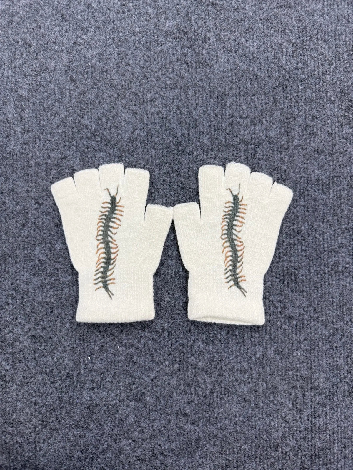Pair of off-white fingerless knit gloves with a brown printed snake design on the back