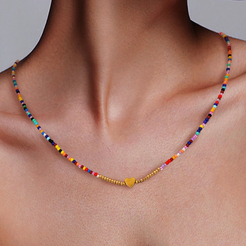 Nahaufnahme einer farbenfrohen, perlenbesetzten Boho-Herzen-Anhänger-Kette um den Hals getragen.