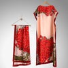 Une grande étole cape couleur pêche fluide avec un motif de papillon floral rouge vif et de paon.