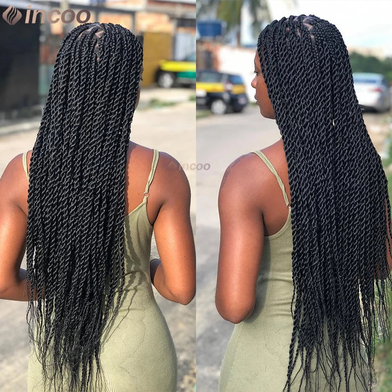 Eine Frau mit langen schwarzen Boxbraid-Zöpfen von hinten, die ein hellgrünes Kleid trägt.