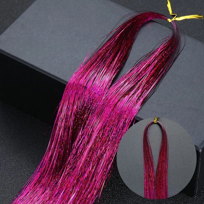 Long, vibrant magenta glitter hair extensions displayed against a dark background.