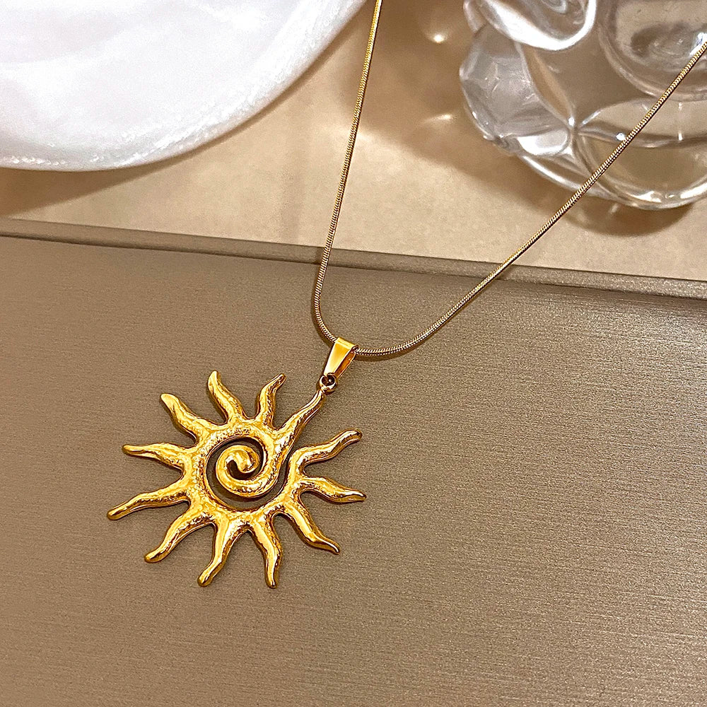 Collier de tournesol spiral plaqué or affiché sur fond neutre.