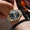 A close-up shot of a men's luminous quartz wristwatch with a gold-toned case and silver bracelet on a wrist.