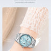 A close-up of an elegant stainless steel wristwatch with a light blue luminous dial and a pink lace cuff on a hand.