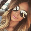 Close-up photo of a woman wearing aviator sunglasses with gold frames