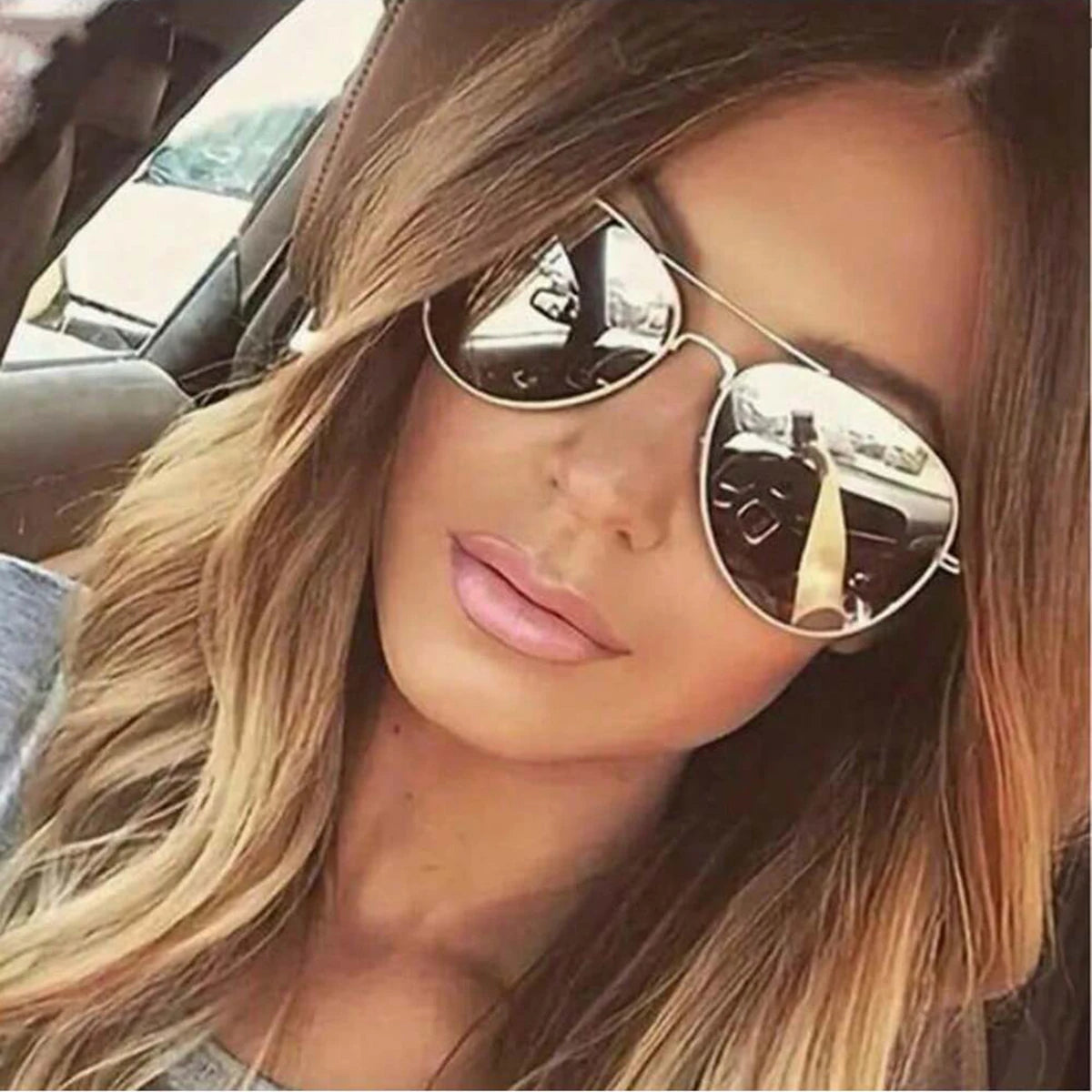 Close-up photo of a woman wearing aviator sunglasses with gold frames
