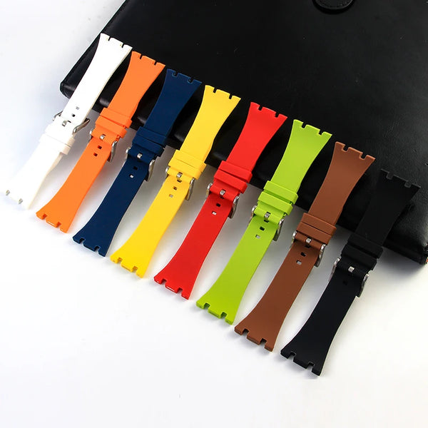 A collection of colorful silicone watch bands in various colors laid out on a black surface.