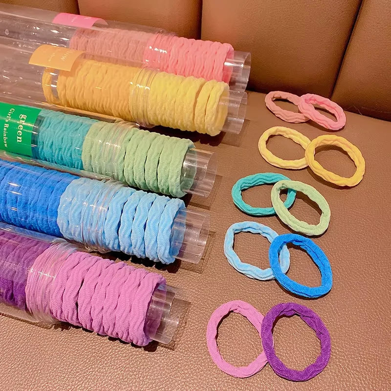 Colección de 20 paquetes de gomas para el pelo con rayas onduladas y colores como rosa, amarillo, verde, azul y morado.