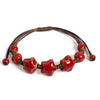 A handmade glazed ceramic star bracelet with reddish-brown beads and leather cord.