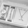 A white box contains an elegant quartz wrist watch, a diamond necklace, and a ring.