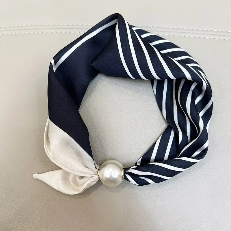 Navy and white striped silk scarf tied in a knot with a pearl magnetic clasp